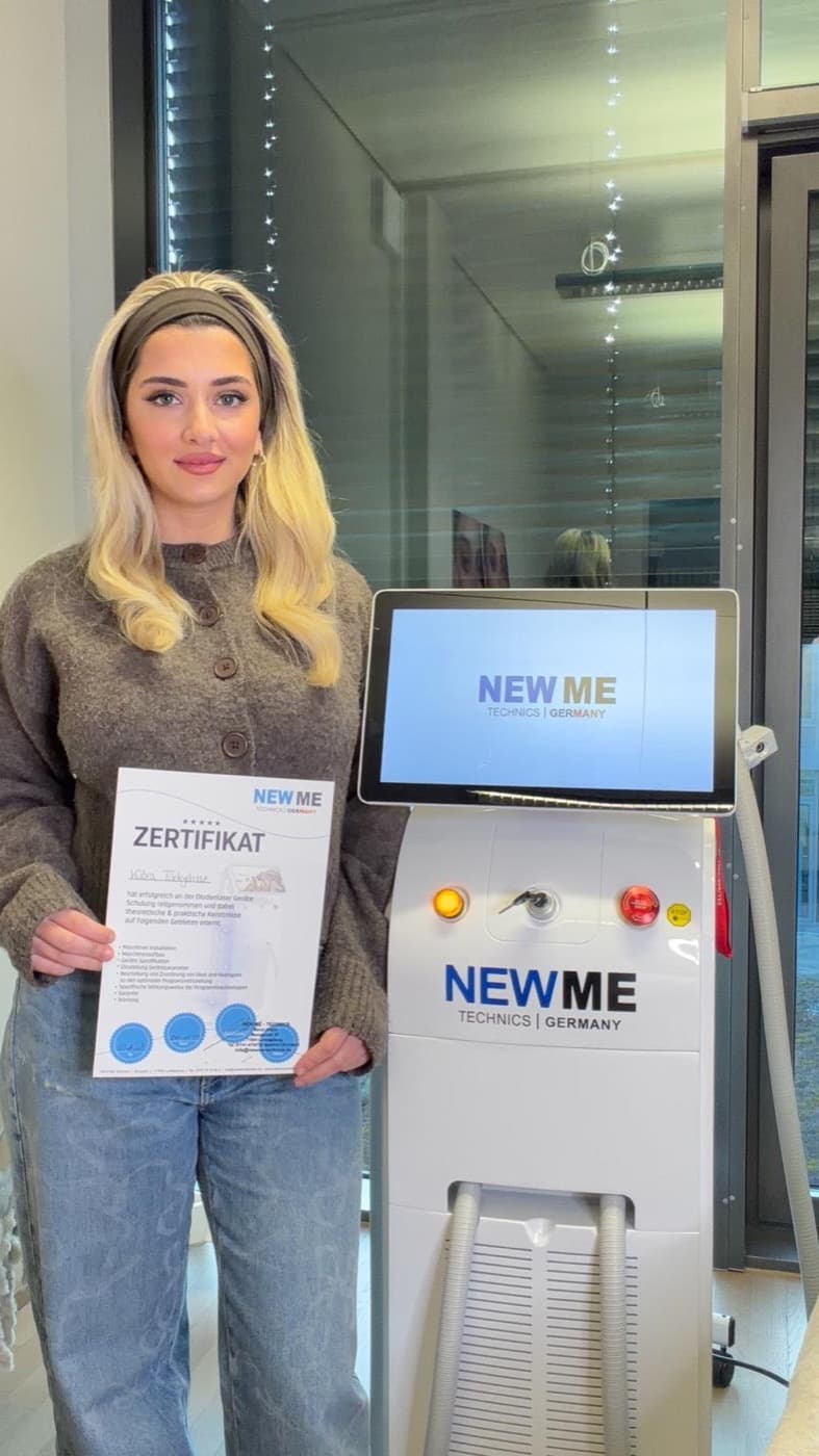 Studiobetreiberin mit Teilnahmezertifikat neben dem Focus Laser 4D.